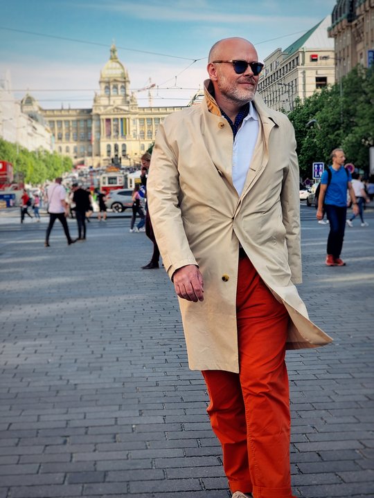 Petr Lukeš wearing a beige coat and orange trousers
